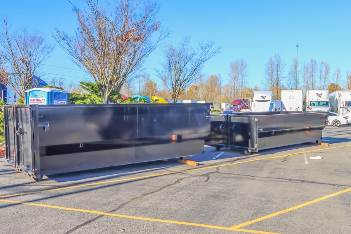 Professional dumpster rental service with roll-off container on residential driveway in Montgomery